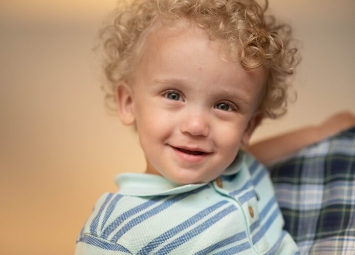 Happy and Healthy Greyson, Smiling while being held by his father.