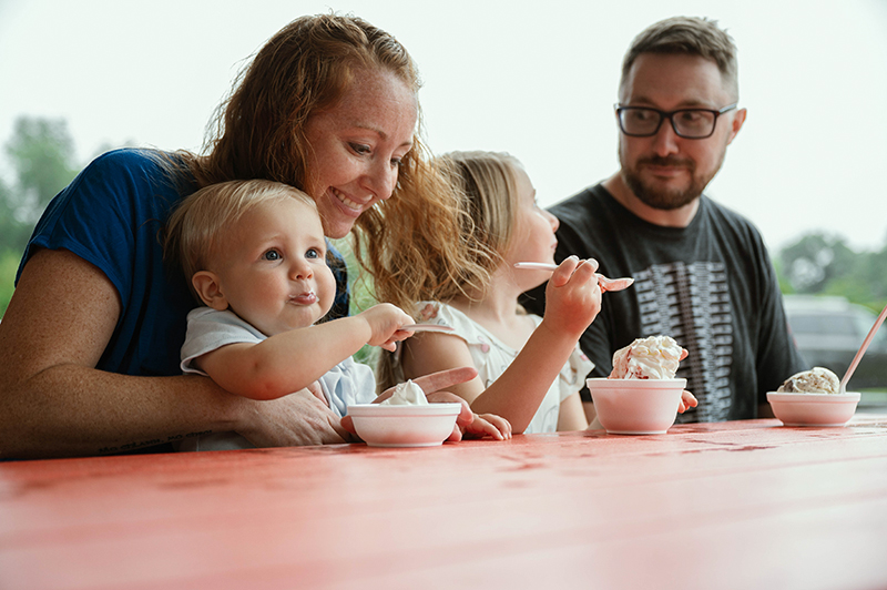 Family sitting on a table eating ice cream