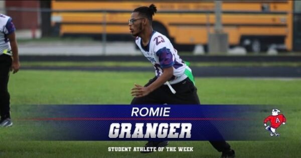 Romie Granger running a football play with a banner that says he is Student Athlete of the Week for Adams high school