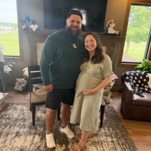 Andrew Harbin, left, stands with Taylor Harbin as she cradles her pregnant belly in September 2026.