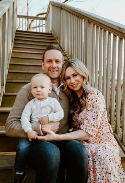 Lee and Jane Hershberger sit with their child, Aleks, on an outdoor staircase.